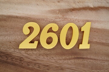 Golden Arabic numerals on a real brown and white wooden floor number 2601