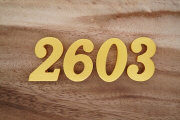 Golden Arabic numerals on a real brown and white wooden floor number 2603