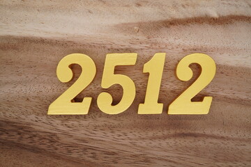 Golden Arabic numerals on a real brown and white wooden floor number 2512