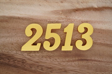 Golden Arabic numerals on a real brown and white wooden floor number 2513