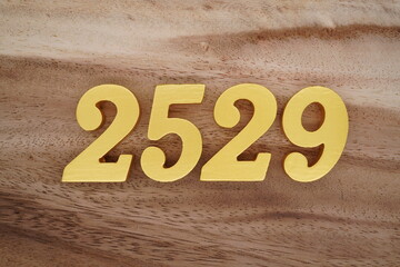 Golden Arabic numerals on a real brown and white wooden floor number 2529