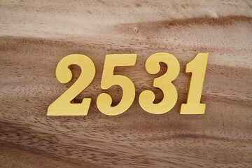Golden Arabic numerals on a real brown and white wooden floor number 2531