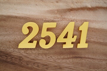Golden Arabic numerals on a real brown and white wooden floor number 2541
