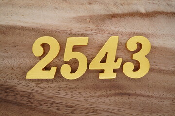 Golden Arabic numerals on a real brown and white wooden floor number 2543