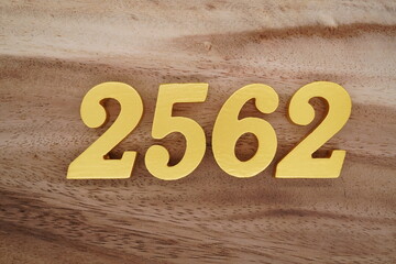 Golden Arabic numerals on a real brown and white wooden floor number 2562