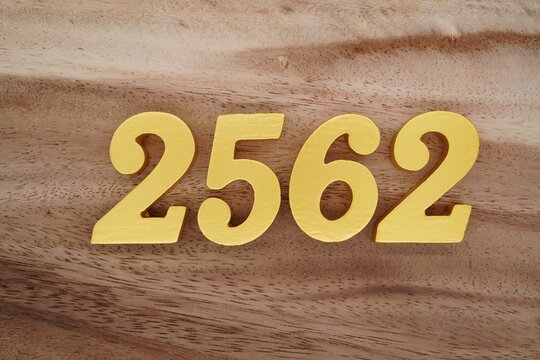 Golden Arabic numerals on a real brown and white wooden floor number 2562