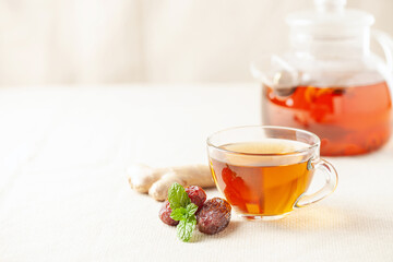 Hot warming tea with dates and ginger in a glass cup on the table. Immune drink