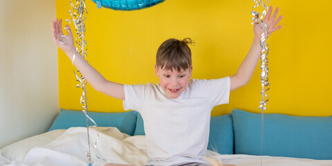 The inflatable figure 8 is in the hands of a contented happy boy. A boy in his room is playing with...