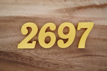 Golden Arabic numerals on a real brown and white wooden floor number 2697