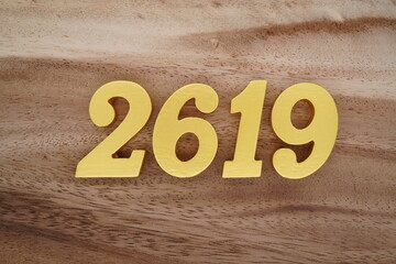 Golden Arabic numerals on a real brown and white wooden floor number 2619