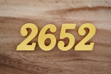 Golden Arabic numerals on a real brown and white wooden floor number 2652