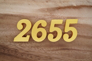 Golden Arabic numerals on a real brown and white wooden floor number 2655
