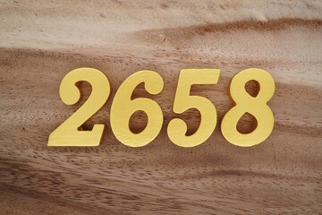 Golden Arabic numerals on a real brown and white wooden floor number 2658