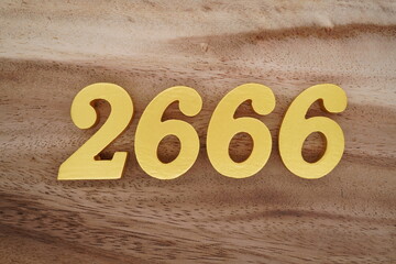 Golden Arabic numerals on a real brown and white wooden floor number 2666