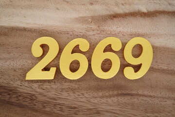 Golden Arabic numerals on a real brown and white wooden floor number 2669