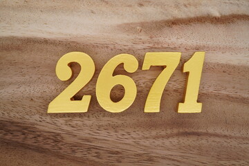 Golden Arabic numerals on a real brown and white wooden floor number 2671