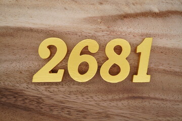 Golden Arabic numerals on a real brown and white wooden floor number 2681