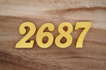 Golden Arabic numerals on a real brown and white wooden floor number 2687