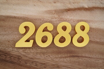 Golden Arabic numerals on a real brown and white wooden floor number 2688