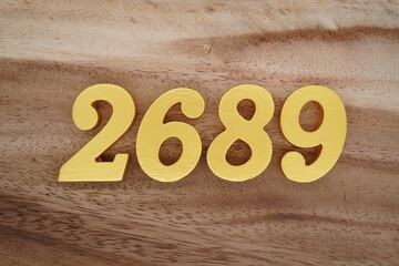 Golden Arabic numerals on a real brown and white wooden floor number 2689