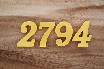 Golden Arabic numerals on a real brown and white wooden floor number 2794