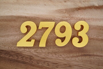 Golden Arabic numerals on a real brown and white wooden floor number 2793