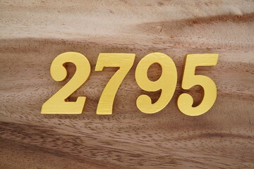 Golden Arabic numerals on a real brown and white wooden floor number 2795