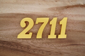 Golden Arabic numerals on a real brown and white wooden floor number 2711