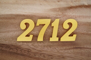 Golden Arabic numerals on a real brown and white wooden floor number 2712