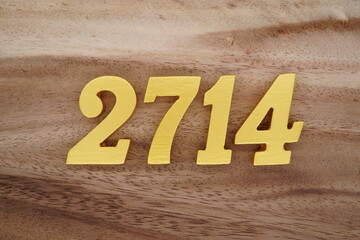 Golden Arabic numerals on a real brown and white wooden floor number 2714