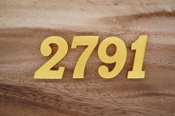 Golden Arabic numerals on a real brown and white wooden floor number 2791