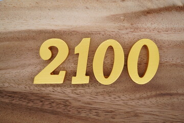Golden Arabic numerals on a real brown and white wooden floor number 2100