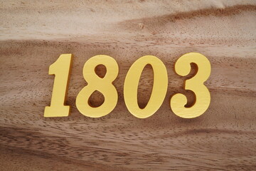Golden Arabic numerals on a real brown and white wooden floor number 1803