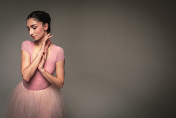 portrait of a young pretty, fragile, beautiful ballerina in a long pale pink dress with tulle on a...