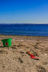 A child's shovel and pail on a rocky puget sound beach