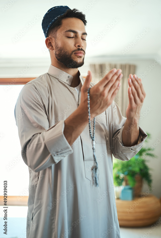 Wall mural prayer isnt asking. it is a longing of the soul. shot of a young muslim man praying in the lounge at