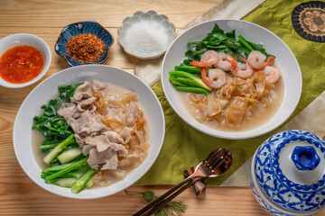 Shrimp Wide Rice Noodles and Pork Wide Rice Noodles with  kale in Gravy Sauce  Served with condiments, chili powder , chili sauce and sugar. Asian food.