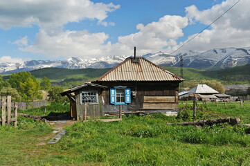 Ridder, Kazakhstan - 06.05.2013 : An old house with an outbuilding in the middle of a hilly plain
