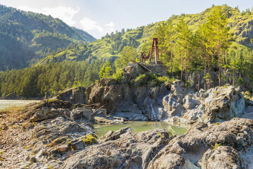 Fototapeta na wymiar Dilapidated bridge across the Katun River in Altai