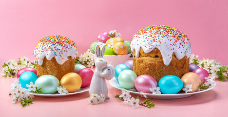 Easter cake with eggs porcelain rabbit and cherry blossoms. On a pink background.