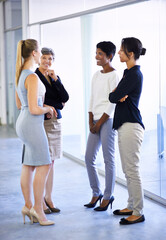 Fototapeta premium Office catch-up after the weekend. Shot of a group of business colleagues having a conversation in the office.