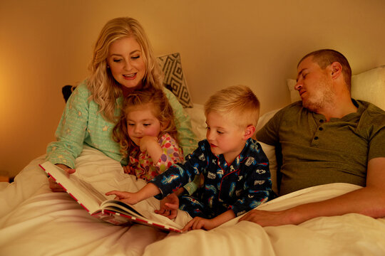 The story has already put Dad to sleep. Cropped shot of a family reading a bedtime story together at home.