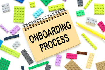 ONBOARDING PROCESS notepad with text on a background of multi-colored cubes