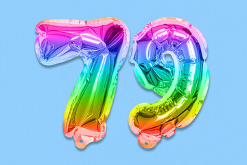 Rainbow foil balloon number, digit seventy nine on a blue background. Birthday greeting card with inscription 79. Top view. Numerical digit. Celebration event, template.