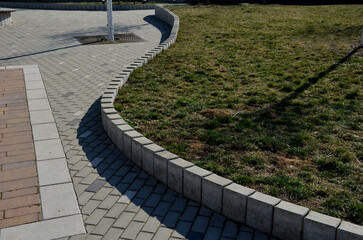 Palisades made of square-profile concrete with sloping staircase arches in garden architecture. solution of smaller terrain differences, support of slopes for edging raised flower beds on construction