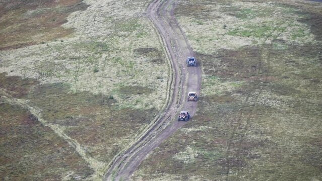 Group Of Buggy Cars Driving On A Dirt Road In The Mountains