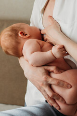 Young woman breastfeeding her baby at home