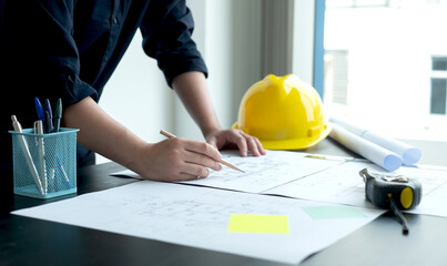 Architects or engineers working construction and drawing construction plans, printing, writing on-site construction sites. Home design concept