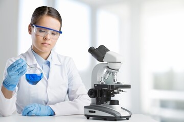 Beauty woman scientist in goggles, research study using microscope