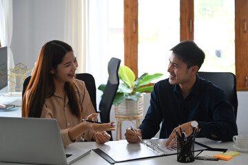 Two business partner discussing project strategy while having conversation on financial data report together.